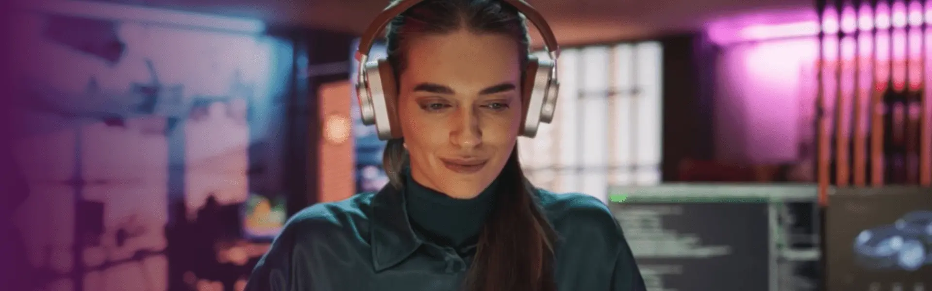 一名女性戴著耳機面朝前,使用 Lenovo Device Orchestration 專注於工作空間中的螢幕。