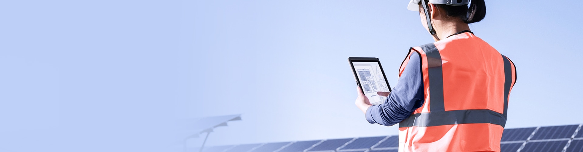 Worker using a Lenovo tablet at a solar energy site.