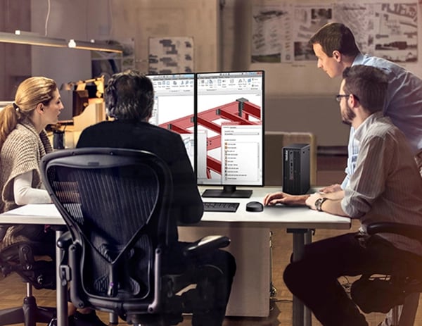 Group of architects at a desk, looking at large monitor showing building designs, next to Lenovo ThinkStation P3 Ultra Workstation