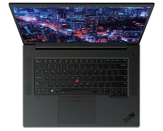 Aerial view of forward-facing  Lenovo ThinkPad P1 Gen 6 (16″ Intel) mobile workstation, opened, showing full keyboard & display with a night skyscraper scene
