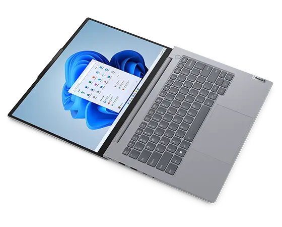 Overhead shot of the Lenovo ThinkBook 14 Gen 6 laptop floating horizontally, with focus on Windows 11 display, keyboard, & right-side ports. 
