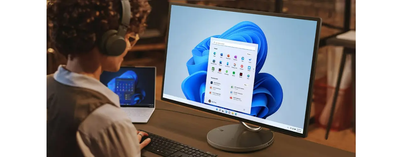 Person working on Yoga AIO 9i Gen 8 with optional keyboard and laptop next to it
