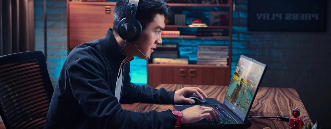 A gamer in a headset eagerly engages with the game he’s playing on the Legion Slim 5 Gen 9 (16 AMD)