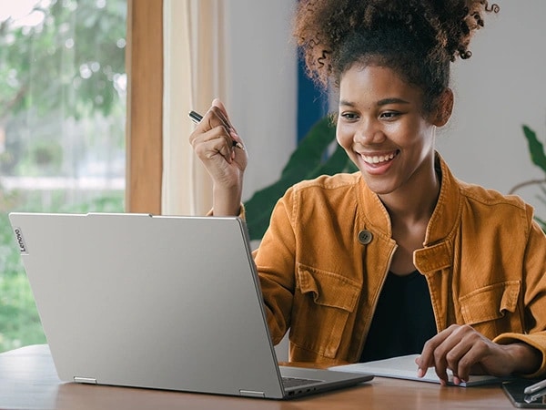 Women in cafÃ© working on Lenovo IdeaPad 5 2-in-1 Gen 9 (16â€ Intel)