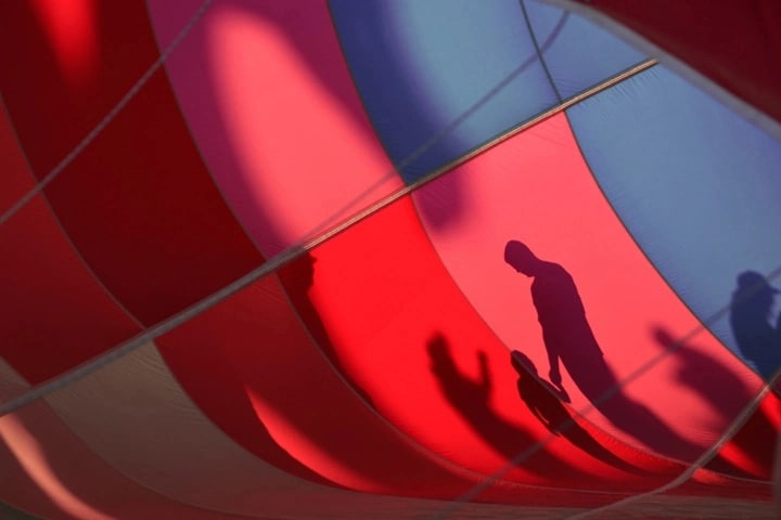The shadows of a mom, dad and child cast onto a colorful backdrop