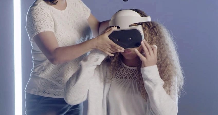 woman helping another woman put on a VR headset