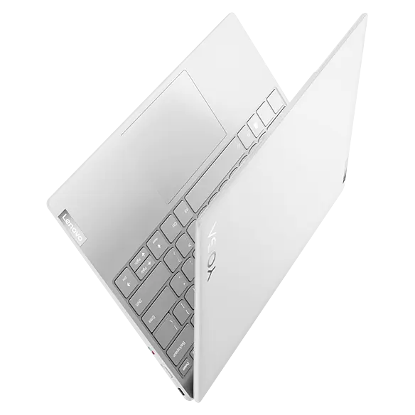Aerial view of Yoga Slim 7i Carbon laptop at angle, opened 45 degrees in  a V-shape, showing top cover, part of keyboard, & right-side ports