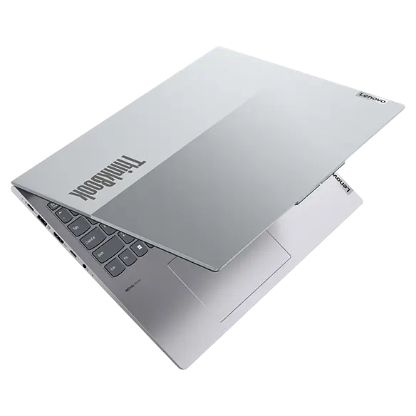 Overhead shot of Lenovo ThinkBook 16 Gen 4 laptop showing dual-tone top cover barely open & showing partial keyboard.