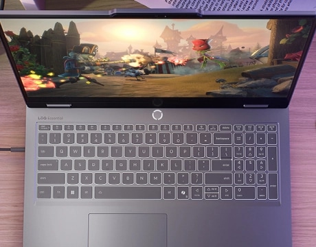 Lenovo LOQ Essential 15IRX11 gaming laptop on a desk – view from above, lid open with gaming screen on the display.