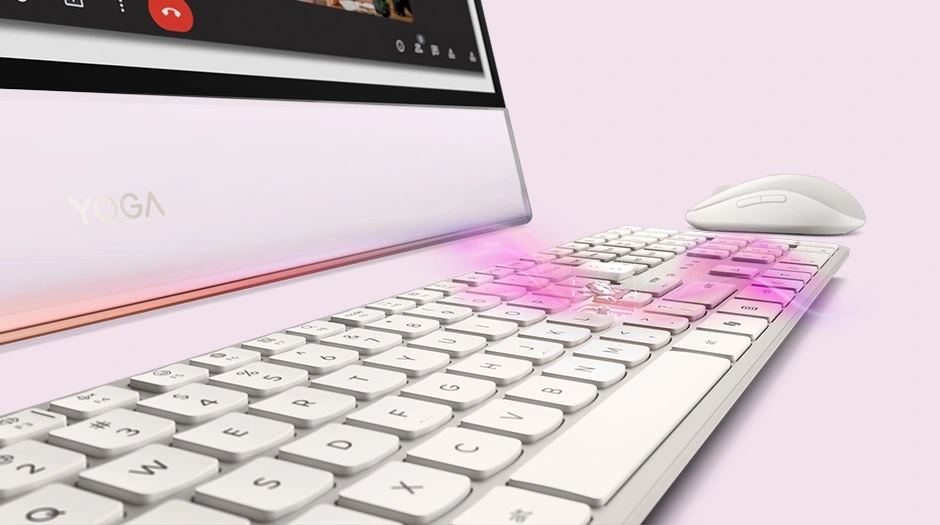 A stylish workspace with a glowing keyboard and video call interface, featuring the Lenovo Yoga AIO i Gen 11 Aura Edition PC.