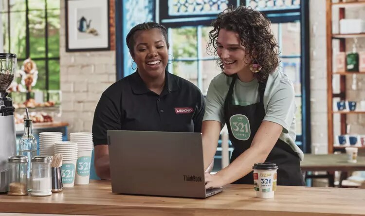 Employee of 321 Coffee in Raleigh, North Carolina and Lenovo employee work on Lenovo ThinkBook
