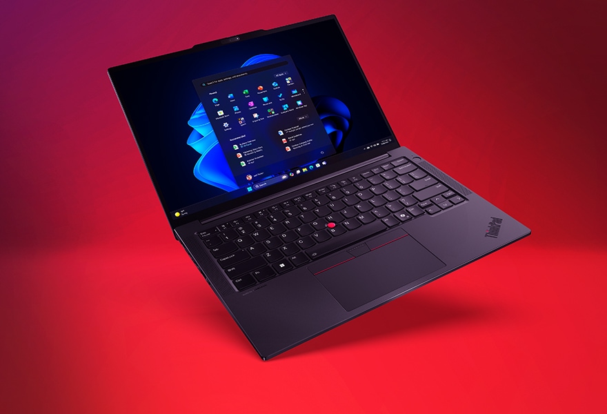 Open Lenovo ThinkPad laptop angled on a red background, displaying the Windows 11 interface on screen with a full keyboard and trackpad visible.