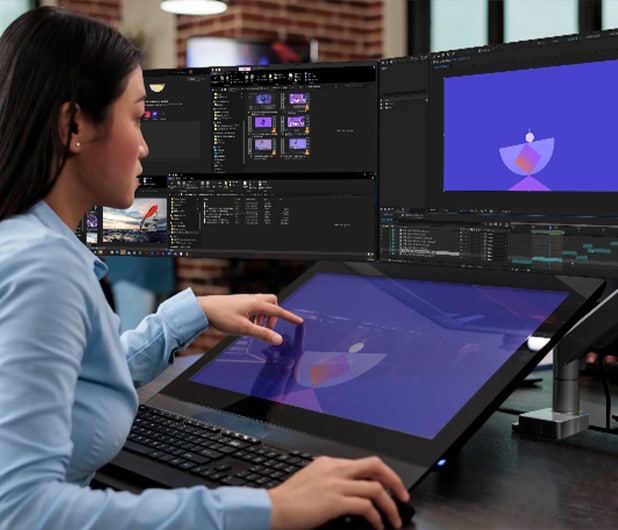 A woman using a thinkstation desktop workstation to create video graphics on graphic design software