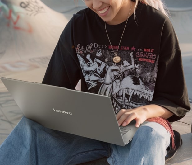 A young woman using her lenovo laptop to edit photos on the go