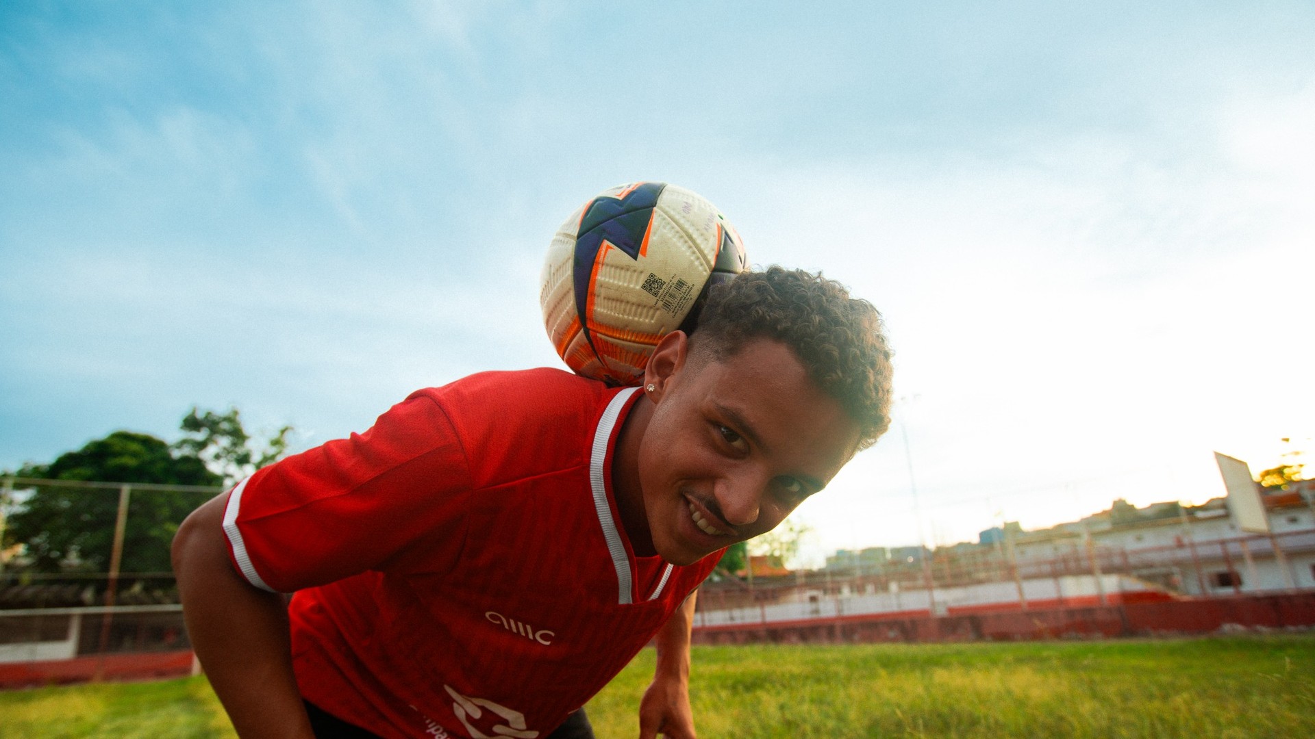 Football player balancing a ball on his shoulder