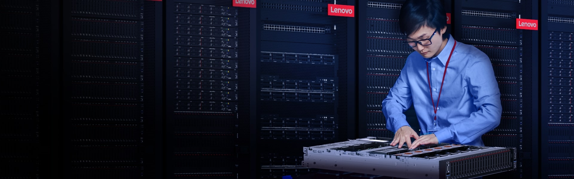 Technician working on a Lenovo server inside a data center rack environment, surrounded by Lenovo-branded server racks