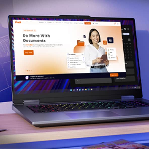 The image shows a person using a Lenovo laptop in a work environment. The laptop is open, and the screen displays a document editing interface, specifically a Foxit file, which includes graphics and text highlighted in orange. The person's hand is on the keyboard, suggesting they are interacting with the content on the screen.