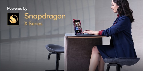 A womand working on a desk with a Lenovo Laptop