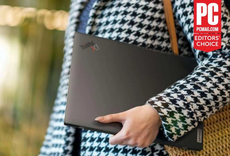 Person carrying ultraportable Lenovo ThinkPad X1 Carbon Gen 10 laptop under their arm