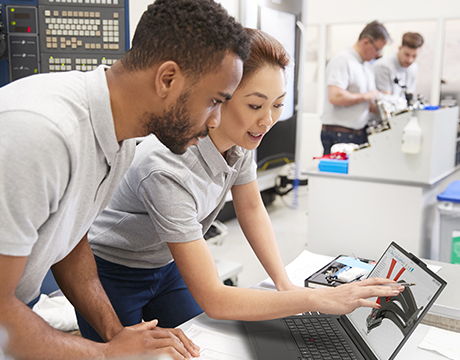 Two engineers discussing a 3D model displayed on the Lenovo ThinkPad P14s Gen 7 (14" Intel) laptop.