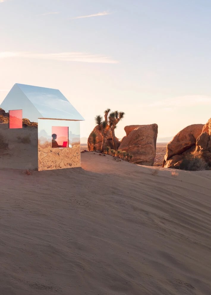 Маленький дом с отражающими свет стенами посреди пустыни.