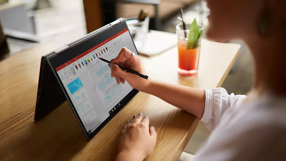 Lenovo ThinkPad X1 Yoga in tent mode, with someone using a digital stylus.