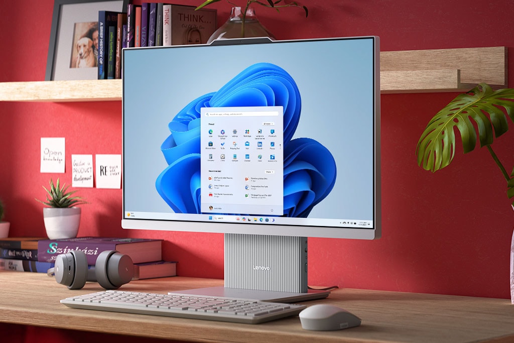 Přední počítač Lenovo IdeaCentre All-in-One na stole s nabídkou Start systému Windows 11 Home na displeji.