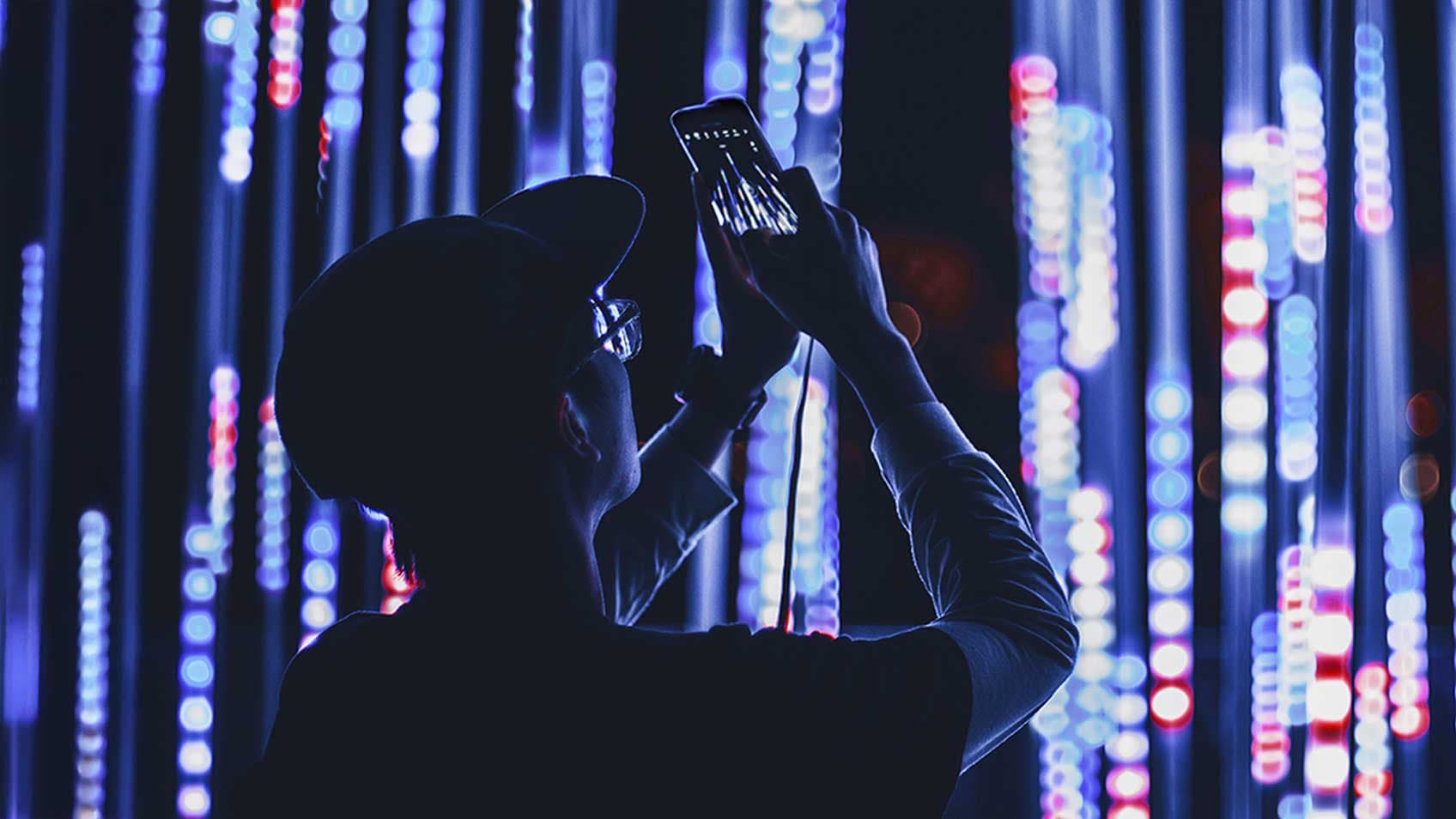 A person taking a picture of lights on their phone