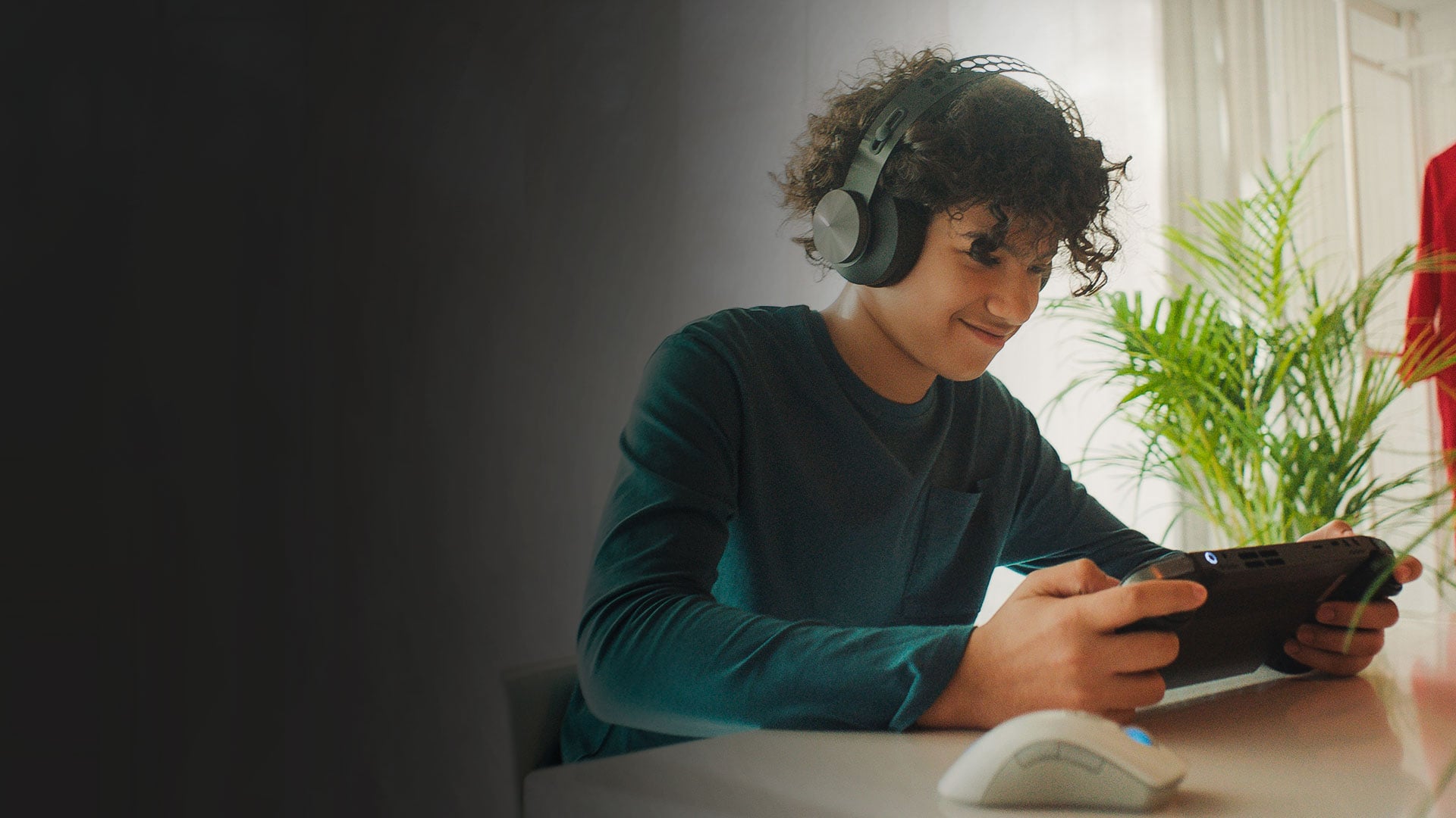 A kid playing on a Lenovo Legion Go and wearing headphones.