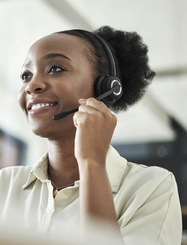 A woman smiling while using a headset