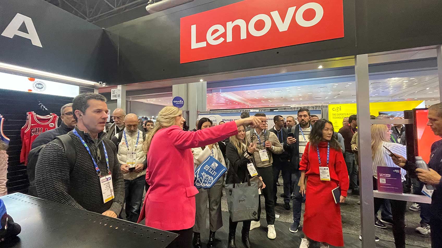 Gente reunida para ver una demostración en el stand de Lenovo en la conferencia de la National Retail Foundation en Nueva York.