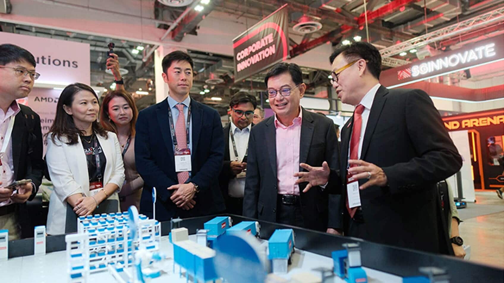 Conference attendees looking at three-dimensional models on a tabletop. 