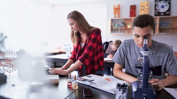 Picture of students in a classroom using microscopes. 