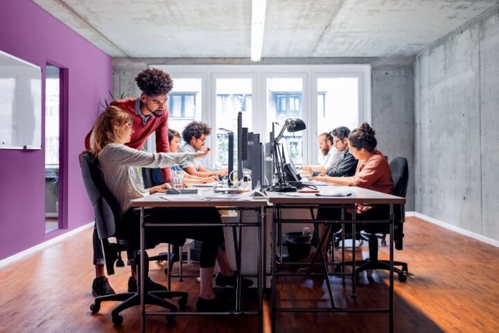 Workers with computers sitting at a conference table