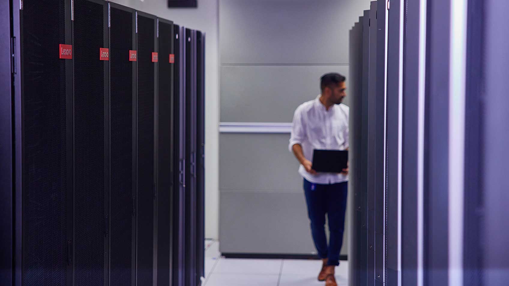 A man walking through a row of servers