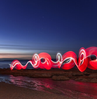 Une ligne rouge agitée illuminée au-dessus de la plage au crépuscule