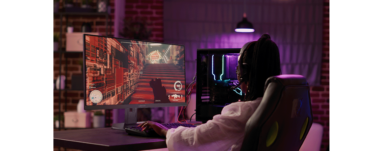 A woman at a desk, engaged with the legion 27u-10 monitor, surrounded by a tidy gaming space.