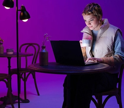 Молодая женщина работает за столом с ноутбуком Yoga Slim