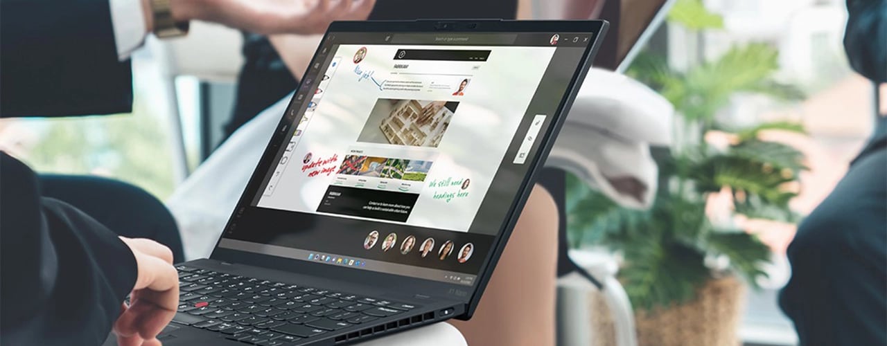 Une personne tape sur le clavier du Lenovo ThinkPad X1 Nano posé sur ses genoux, présentant des images et des notes à l’écran.