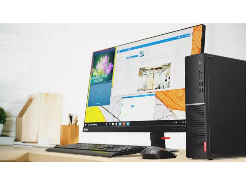 Smaller form factor Lenovo v520 desktop front view, vertically positioned next to monitor, keyboard, and mouse.
